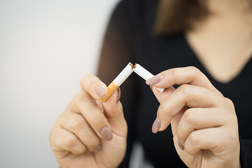 Woman breaking cigarette